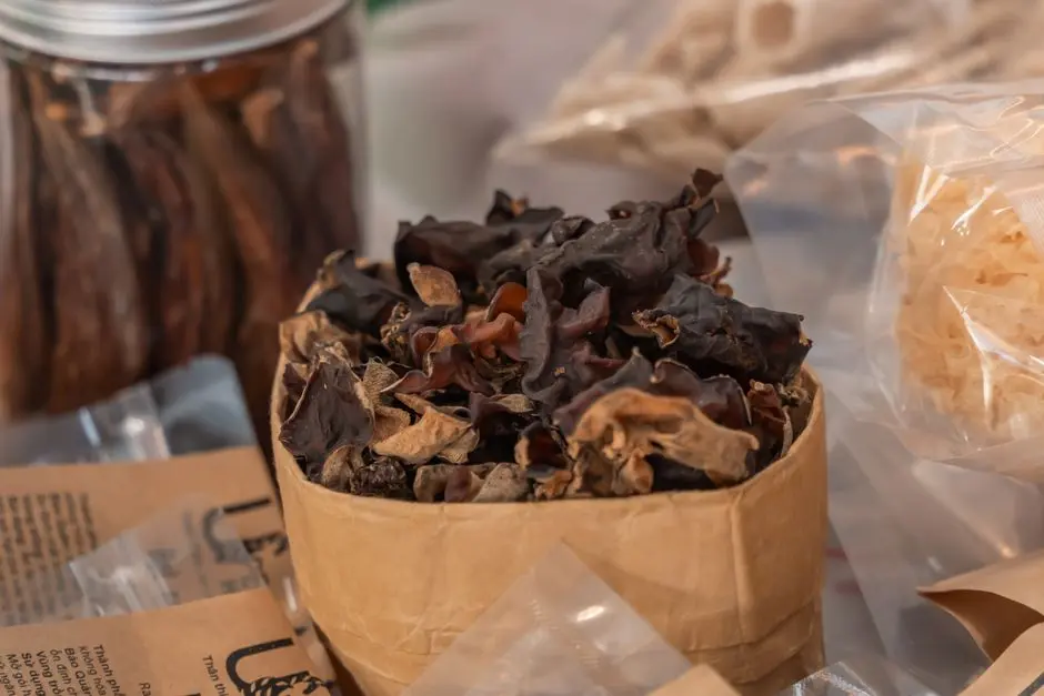Tas anyaman dari daun pandan dan kopi bubuk kemasan plastik di atas meja kayu
