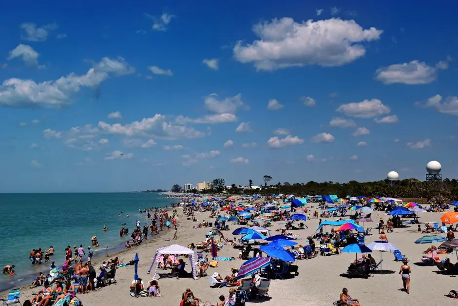 Pantai ramai dengan pengunjung pemula menikmati suasana liburan santai
